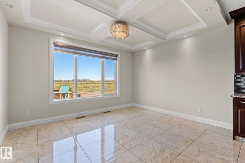 Tray ceiling with recessed lighting and a decorative chandelier - 229 Albany Drive Nw, Edmonton, AB 