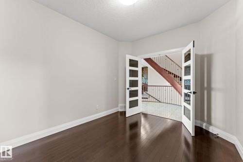 Dark wood-finish flooring, white walls, and a textured ceiling - 229 Albany Drive Nw, Edmonton, AB 