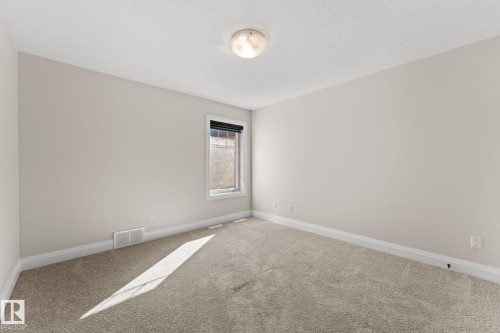 Recessed window with white trim, light neutral wall color, textured ceiling, and light-colored carpeting - 229 Albany Drive Nw, Edmonton, AB 