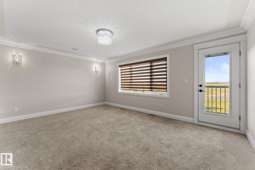 Plush carpeting, crown molding, and two decorative wall sconces - 229 Albany Drive Nw, Edmonton, AB 