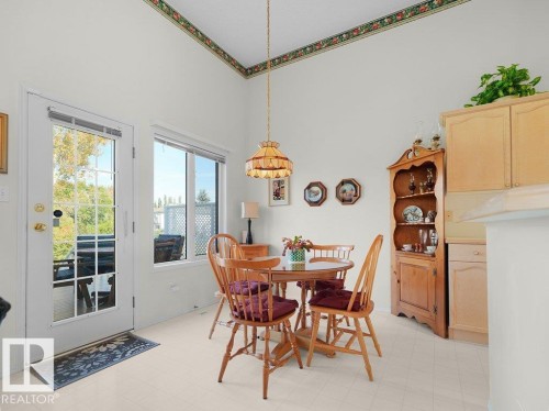 High vaulted ceiling, white walls, light-toned flooring, and a glass-paneled exterior door - 156 Phillips Row Nw, Edmonton, AB 