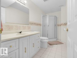 White cabinet vanity with gold-tone hardware, an integrated sink, and a framed mirror - 