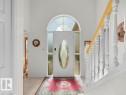 Entryway featuring a white door with an oval glass insert, transom window, side lights, and tile flooring - 156 Phillips Row Nw, Edmonton, AB 