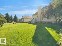 Expansive rear lawn with mature trees and established landscaping - 