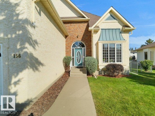 Stucco and brick facade with an arched entry door - 156 Phillips Row Nw, Edmonton, AB 