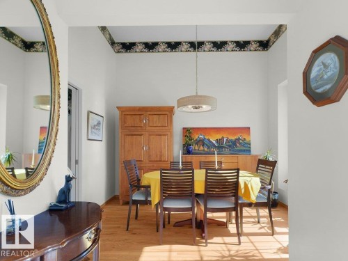Wood-finish flooring with a drum pendant light fixture - 156 Phillips Row Nw, Edmonton, AB 
