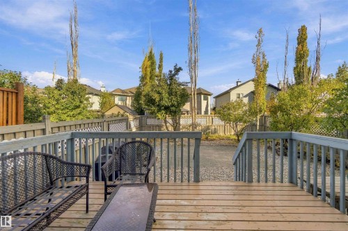 Spacious wood-finish deck with railings, providing access to a graveled yard area - 3524 Mclean Crescent Sw, Edmonton, AB 