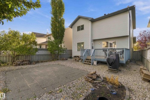 Rear exterior featuring light-colored siding, a multi-level wooden deck with blue railings, and a fenced perimeter - 3524 Mclean Crescent Sw, Edmonton, AB 