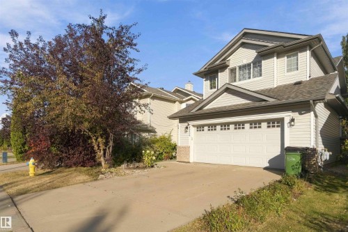 Two-story residence with light-colored siding, an attached two-car garage, and a concrete driveway - 3524 Mclean Crescent Sw, Edmonton, AB 