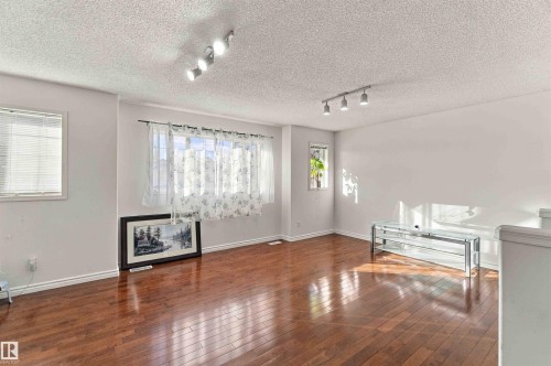 Hardwood flooring throughout, multiple windows, and track lighting fixtures - 3524 Mclean Crescent Sw, Edmonton, AB 