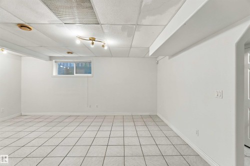 White tile flooring, track lighting, recessed lighting, white walls, and a window with horizontal blinds - 3524 Mclean Crescent Sw, Edmonton, AB 