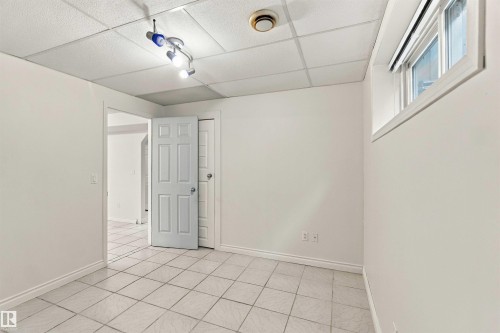 White tiled flooring, white painted walls, white framed window, square panel ceiling, track lighting fixture - 3524 Mclean Crescent Sw, Edmonton, AB 