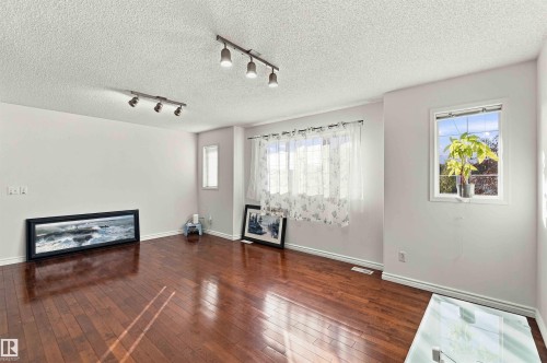 Hardwood flooring, track lighting fixtures, white walls, and multiple windows - 3524 Mclean Crescent Sw, Edmonton, AB 