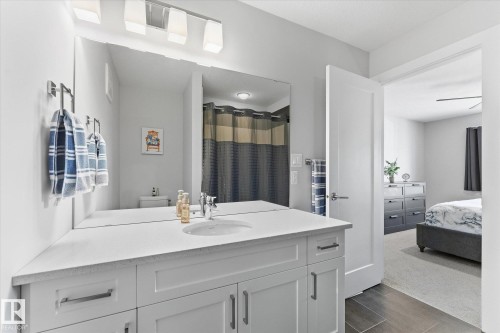 Bathroom vanity with integrated sink, expansive mirror, and chrome fixtures - #15 4835 Wright Dr Sw, Edmonton, AB 