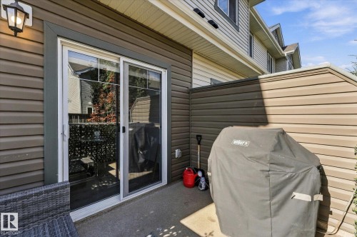 Paved patio area featuring durable siding and a permanent privacy wall - #15 4835 Wright Dr Sw, Edmonton, AB 