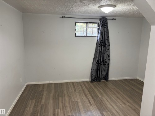 Wood-finish flooring with white trim and a flush-mount ceiling light - 7623 130 Avenue Nw, Edmonton, AB 