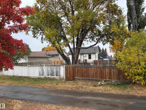 Wood fencing and white picket fence enclosing the property - 7623 130 Avenue Nw, Edmonton, AB 