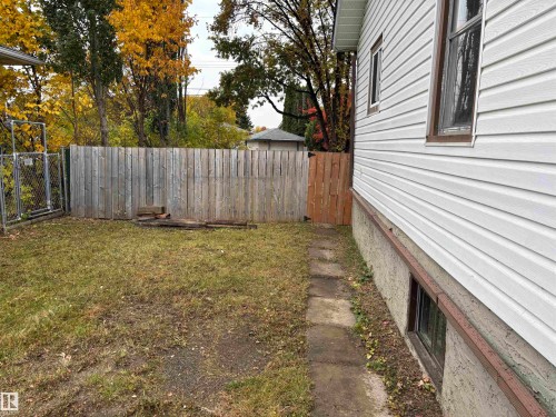 Chain link fencing, wood privacy fencing, a wood gate, and a concrete paver pathway - 7623 130 Avenue Nw, Edmonton, AB 