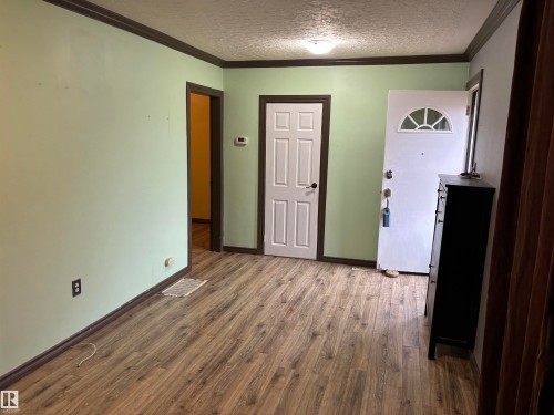 Wood-finish flooring throughout, light green wall finishes, and ceiling-mounted light fixture - 7623 130 Avenue Nw, Edmonton, AB 