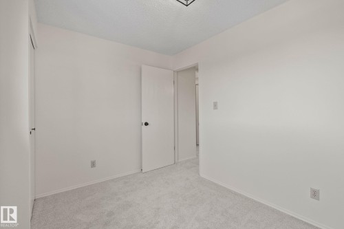 Light-toned carpeting, white walls, and a ceiling-mounted light fixture - 14411 23 Street Nw, Edmonton, AB 