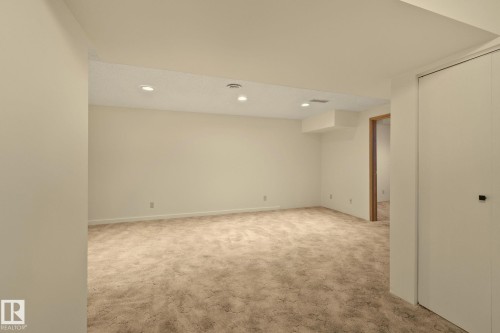 Recessed ceiling lighting, textured ceiling, light-toned walls, carpeted flooring, and a built-in closet with white bifold doors - 14411 23 Street Nw, Edmonton, AB 