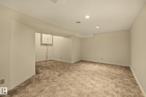 Expansive carpeted area with recessed ceiling lighting and neutral wall finishes - 14411 23 Street Nw, Edmonton, AB 