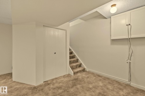 Carpeted flooring, built-in storage cabinets, and an overhead light fixture - 14411 23 Street Nw, Edmonton, AB 