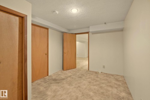 Neutral-toned carpet flooring, light-colored walls, recessed ceiling lighting, and wood-finish doors - 14411 23 Street Nw, Edmonton, AB 