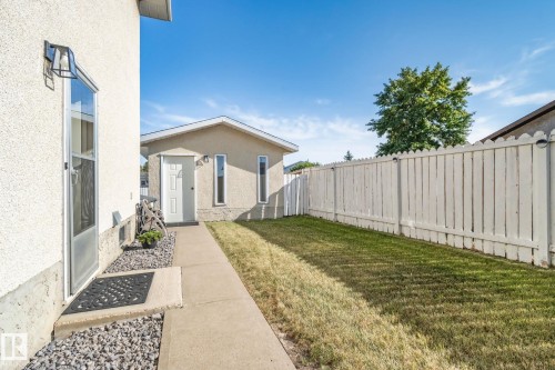 Detached structure with exterior lighting, concrete walkway, gravel landscaping, and a fenced yard - 14411 23 Street Nw, Edmonton, AB 