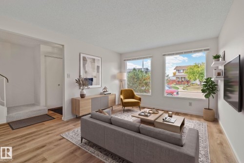 Bright living area with large windows, wood-finish flooring, and a neutral color palette - 14411 23 Street Nw, Edmonton, AB 