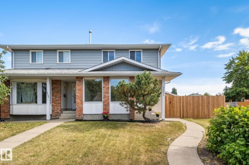 Two-story exterior featuring light blue siding and brick accents - 14411 23 Street Nw, Edmonton, AB 