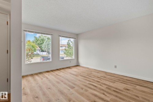 Wood-finish flooring, white painted walls, and two large windows - 14411 23 Street Nw, Edmonton, AB 