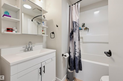 White vanity with matte black hardware, integrated sink, and chrome faucet - 9020 152 Street Nw, Edmonton, AB 