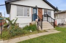 Entry steps with black metal railings, a blue front door, and a wall-mounted outdoor light fixture - 9020 152 Street Nw, Edmonton, AB 