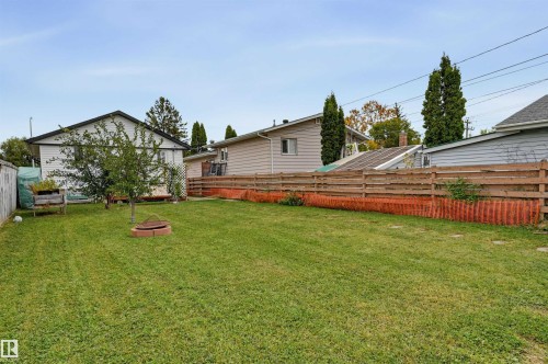 Expansive backyard featuring a manicured lawn, established tree, and wood-panel fencing - 9020 152 Street Nw, Edmonton, AB 