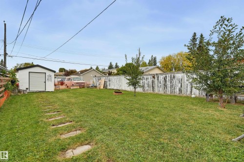 Expansive green lawn with a white storage shed and concrete stepping stones - 9020 152 Street Nw, Edmonton, AB 