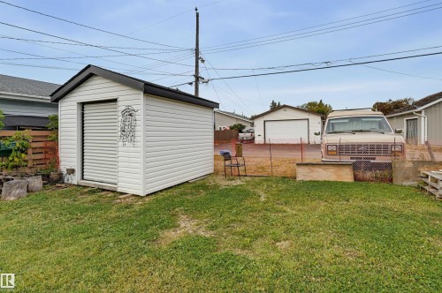 Detached storage shed with white siding and a roll-up door - 9020 152 Street Nw, Edmonton, AB 