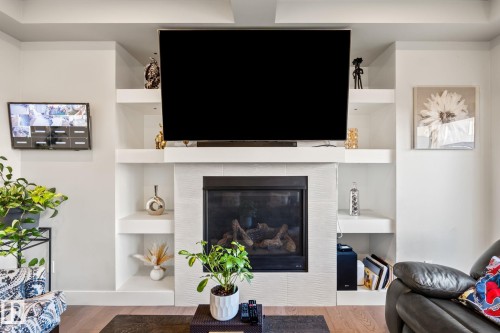 Built-in fireplace with a tile surround, flanked by integrated shelving - 824 34 Ave Nw, Edmonton, AB 