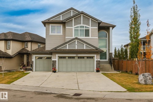 Two-story residence featuring light gray siding with dark gray shingle accents and a multi-pitch roof - 824 34 Ave Nw, Edmonton, AB 