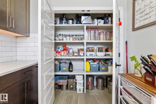 Expansive pantry with built-in shelving, wood-finish flooring, and a flat panel door - 824 34 Ave Nw, Edmonton, AB 