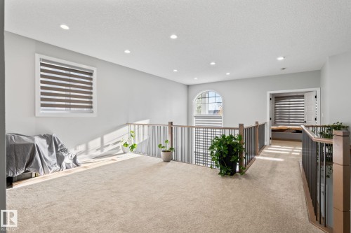 Carpeted landing featuring recessed lighting, a white framed window, and a rounded arch window - 824 34 Ave Nw, Edmonton, AB 