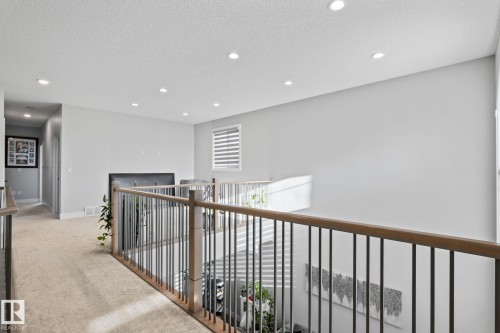 Open loft area featuring recessed lighting, a wood and iron railing, and carpeting - 824 34 Ave Nw, Edmonton, AB 