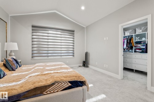 Vaulted ceiling, recessed lighting, window with horizontal blinds, light gray wall finish, and built-in closet storage - 824 34 Ave Nw, Edmonton, AB 