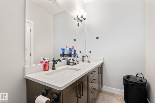 Double vanity with integrated rectangular sinks, light-toned countertop, and dark wood-finish cabinetry - 824 34 Ave Nw, Edmonton, AB 