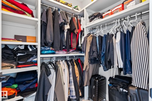 Built-in closet system featuring white shelving and chrome hanging rods - 824 34 Ave Nw, Edmonton, AB 