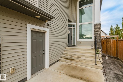 Siding exterior with multiple entry points, stone accent pillar, and prominent multi-level windows - 824 34 Ave Nw, Edmonton, AB 