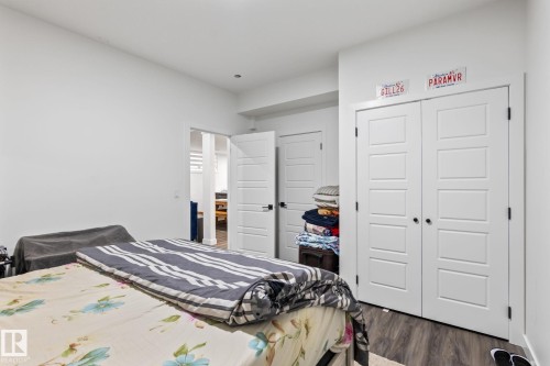 White walls, wood-finish flooring, white paneled doors, and black door hardware - 824 34 Ave Nw, Edmonton, AB 