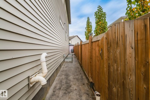 Horizontal siding exterior with a wood fence and concrete walkway - 824 34 Ave Nw, Edmonton, AB 