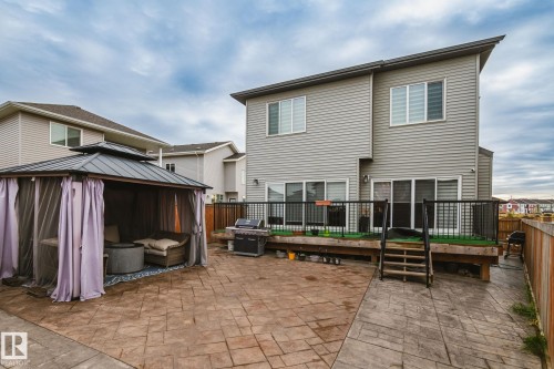 Stamped concrete patio with a tiered deck featuring black metal railings and slatted wood fencing - 824 34 Ave Nw, Edmonton, AB 