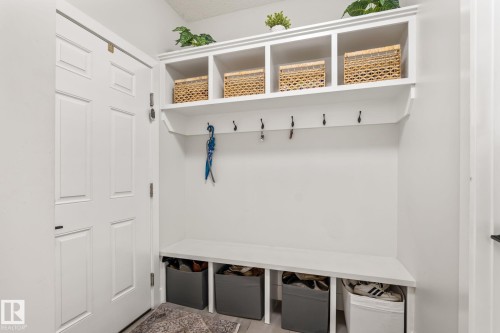Built-in storage bench with open shelving, integrated hanging hooks, and a paneled door - 824 34 Ave Nw, Edmonton, AB 
